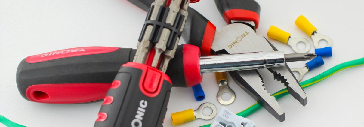 A selection of tools and wires on a white surface