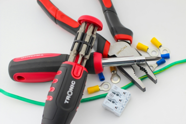 A selection of tools and wires on a white surface