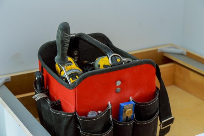 A empty tool bag with only a select few tools.