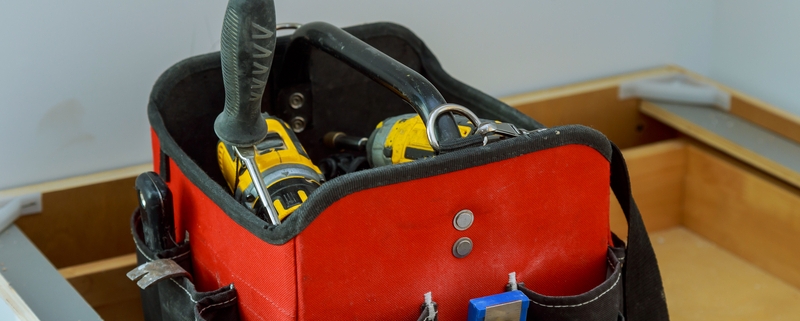 A empty tool bag with only a select few tools.